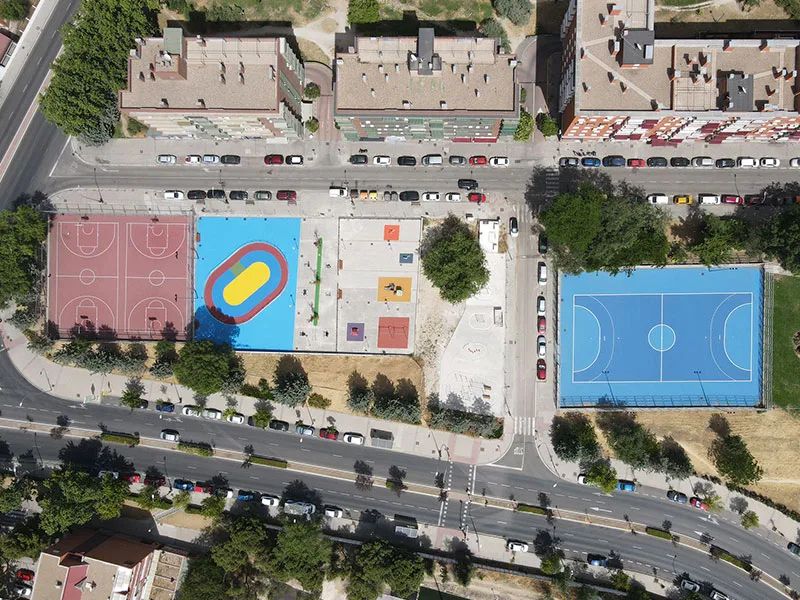 Vista aérea de la construcción e instalación de áreas deportivas en Usera, con canchas de baloncesto, pista de atletismo y zona recreativa. Vista aérea de la construcción e instalación de áreas deportivas en Usera, con canchas de baloncesto, pista de atletismo y zona recreativa.