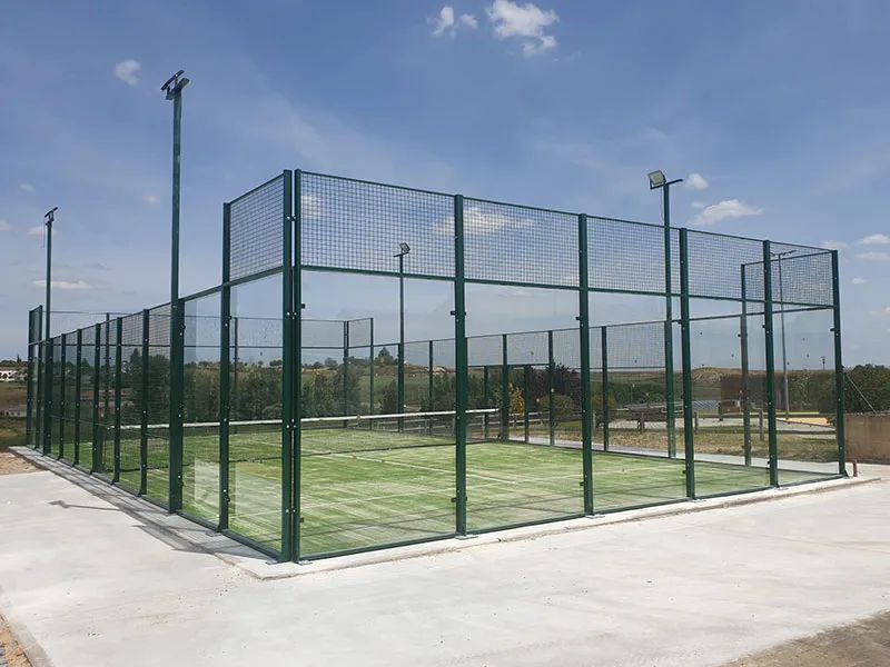 Construcción de pista de pádel de cristal con césped artificial. Pista de pádel de cristal con césped artificial recién construida.